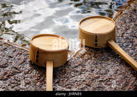 Japanische hölzerne Schöpfkellen am Shinto-Tempel in Kyoto, Japan. In Japan ist ein Tsukubai ein Waschbecken versehen am Eingang zu den Heiligen Stätten für die Besucher p Stockfoto