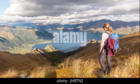 Weibliche Wanderer Blick auf See, Lake Hawea und Berglandschaft, Isthmus Peak, Otago, Südinsel, Neuseeland Stockfoto