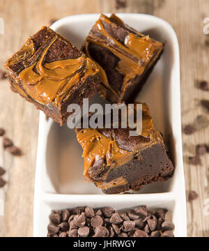 Cantuccini fudge Brownies, in einer weißen Schüssel angezeigt, mit Chocolate Chips. Holz- Hintergrund. Hinweis: Geringe Tiefenschärfe Stockfoto