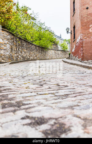 Untere alte Stadt engen Straße mit Kopfsteinpflaster Straße auf Steigung bergauf und Wohn Ziegelhaus und Eingang in Quebec City, Kanada Stockfoto