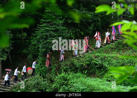 (170716)--Peking, 16. Juli 2017 (Xinhua)--Mitglieder eine Xiaoguangdong Oper Truppe zu Fuß auf einem Pfad im Jianhe County von Qiandongnan Miao und Dong autonomen Präfektur, Südwesten Chinas Provinz Guizhou, 12. Juli 2017. Im Alter von unter 7 Jahre alt, älter als 70 Jahre erbte Mitglieder dieser Truppe der Xiaoguangdong Oper mit einer Geschichte von fast 100 Jahren. Xiaoguangdong Oper ist eine einzigartige und traditionelle Art der Oper, die Popularität in den Bereichen nahe dem Dorf Xiaoguangdong in der Grafschaft Jianhe gewinnt. Festival Zeiten würde die Truppe zu verschiedenen Dörfern Reisen bringen Stockfoto