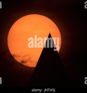 Washington DC, USA. 15. Juli 2017. Die Silhouette der Washington Monument Punkte, um eine riesige Sonnenflecken auf der Sonnenoberfläche wie die Sonne steigt über die Nationen Hauptstadt 15. Juli 2017 in Washington, DC. Der Sonnenfleck ist größer als die Erde und hat Wissenschaftler verblüfft, wie das Phänomen eine Rarität in solaren Minimum ist. Bildnachweis: Planetpix/Alamy Live-Nachrichten Stockfoto