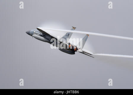 USAF McDonnell Douglas Boeing F-15 Eagle Kampfflugzeug von RAF Lakenheath, das bei einer Flugschau eine Hochgeschwindigkeits-Kraftdemonstration durchführte und eine Wolke aus Feuchtigkeit aus dem Druckluftdruck erzeugt Stockfoto