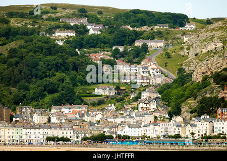 Die Küsten von Llandudno und seine Promenade an einem Sommertag mit Ty-Gwyn Serpentinenstraße, die vorbei über den Great Orme Kalkstein Felsen oben Stockfoto