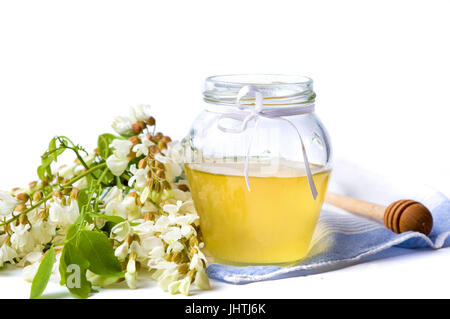 Akazienhonig und Blumen isoliert auf weiss Stockfoto