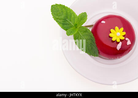 Süße rote Kuchen mit gelben Blüten und Minzeblätter. Auf einem weißen Hintergrund. Geburtstag Dessert. Stockfoto