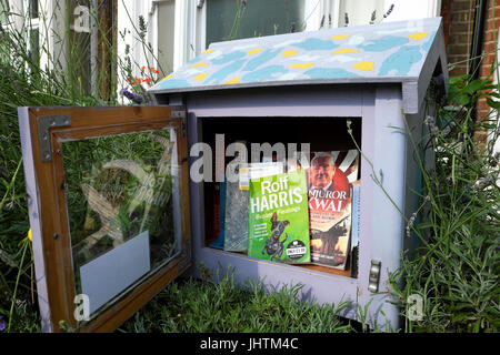 Rolf Harris Kinderbuch über einen Hund "Buster Stadtstreuner" in einer kleinen Free Library Box vor einem Haus in Walthamstow London UK KATHY DEWITT Stockfoto