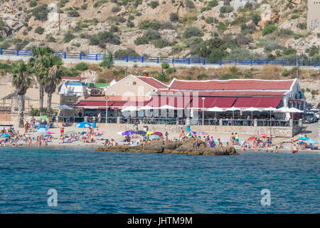 Sonnenanbeter am Strand vor dem Restaurant in Cala Cortina in der Nähe von Cartagena in Murcia Spanien Stockfoto