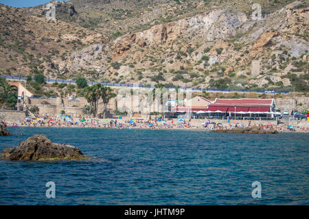 Sonnenanbeter am Strand vor dem Restaurant in Cala Cortina in der Nähe von Cartagena in Murcia Spanien Stockfoto