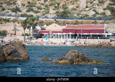 Sonnenanbeter am Strand vor dem Restaurant in Cala Cortina in der Nähe von Cartagena in Murcia Spanien Stockfoto