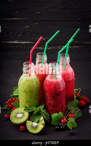 Frische gesunde Smoothies aus verschiedenen Beeren auf einem dunklen Hintergrund Stockfoto