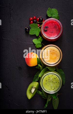 Frische gesunde Smoothies aus verschiedenen Beeren auf einem dunklen Hintergrund. Diät-Menü. Die richtige Ernährung. Flach zu legen. Ansicht von oben Stockfoto