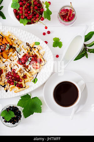 Vielzahl von belgischen Waffeln mit Beeren, Schokolade und Sirup. Stockfoto