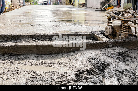 Bau-Männer stehen auf der Seite einer Straße mit neu gegossenen Betonmischung Stockfoto