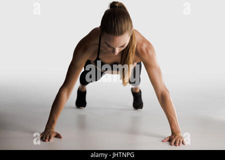 Aufnahme einer Yopung Frau doing Push-ups Stockfoto