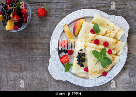 Pfannkuchen mit frischen Beeren von Johannisbeeren, Erdbeeren, Nektarinen, süßen Kirschen und Himbeeren. Stockfoto