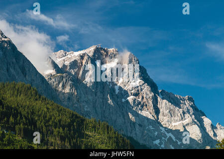 Die Zugspitze, Deutschlands höchstem Berg, aus dem Dorf Grainau in Deutschland im Sommer gesehen. Stockfoto