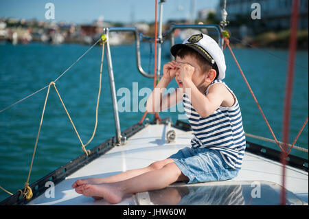 Lustige kleine junge Kapitän auf einer Yacht im Sommer Stockfoto