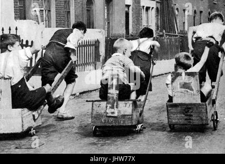 1935, gehen Kinder Kartrennen mit orangefarbenen Feld Karren Stockfoto