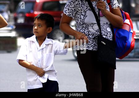 ANTIPOLO CITY, Philippinen - 13. Juli 2017: Ein junger Student geht mit seiner Mutter zur Schule zu gehen. Stockfoto