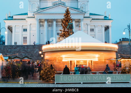 Helsinki, Finnland - 11. Dezember 2016: Weihnachtsmarkt am Senatsplatz mit Festtagskarussell und Wahrzeichen ist lutherische Kathedrale und Denkmal für Ru