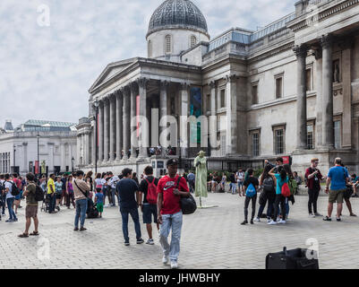 Touristen und einheimische außerhalb der National Gallery am Trafalgar Square in central London. Familien, Freunde, Straße Entertainer, Yoda. Stockfoto