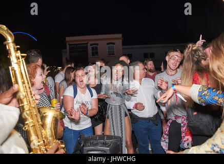 BRISTOL, ENGLAND - Juli 8: Männer und Frauen tanzen und singen wie ein Saxophonist in der Nacht im Bristol Waterfront am 8. Juli 2017 Schnallen Stockfoto