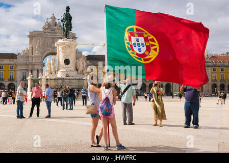 Portugal Tourismus, Aussicht von Touristen fotografiert werden, die die portugiesische Flagge in der Praca do Comercio Platz der Stadt, Lissabon, Portugal. Stockfoto