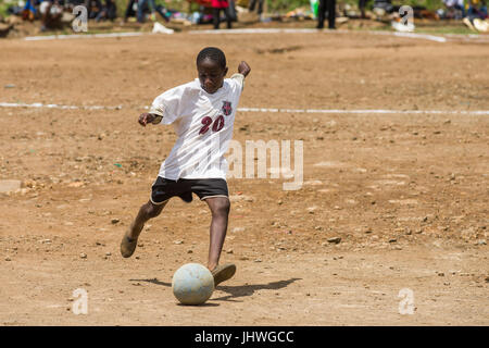 Kinder aus Kibera Slum spielen Fußball auf einem staubigen Platz, Nairobi, Kenia Stockfoto