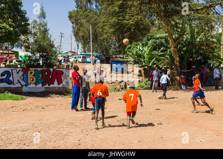 Kinder aus Kibera Slum spielen Fußball auf einem staubigen Platz, Nairobi, Kenia Stockfoto