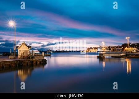Helsinki, Finnland - 9. Dezember 2016: Landschaft der Stadt Pier, Steg am Winter Sonnenaufgang, Sonnenuntergang. Blaue Himmel spiegelt sich im ruhigen Wasser der Meeresoberfläche. Stockfoto