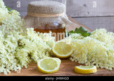 Frische Holunderblüten mit Zitrone und Honig auf einem hölzernen Hintergrund Stockfoto