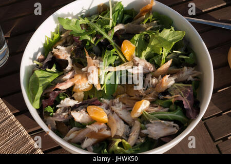 Geräucherte Makrele und Clementine Salat mit Linsen, Orangensaft, Olivenöl, Meerrettich dressing weißes Geschirr Schale im Freien serviert Stockfoto