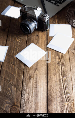 Vintage Foto-Kamera. Leere Bilderrahmen. Alte Fotografien aus Papier, auf Holz Hintergrund, neben modernen computer Stockfoto