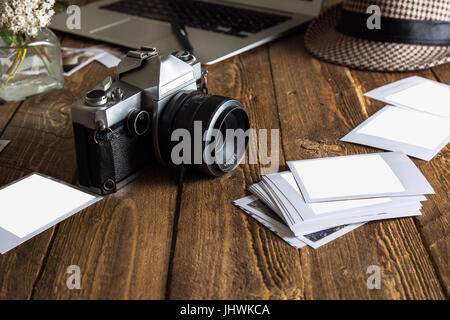 Vintage Foto-Kamera. Leere Bilderrahmen. Alte Fotografien aus Papier, auf Holz Hintergrund, neben modernen computer Stockfoto