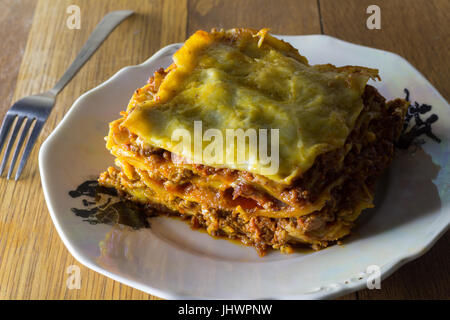 Traditionelle Lasagne mit Hackfleisch-Bolognese-Sauce gemacht und Bechamel-Sauce, garniert mit Mozarella Nahaufnahme romantisches rustikales Abendessen Stockfoto