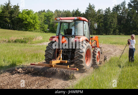 40-50 weibliche Landwirt mit Traktor im Feld Stockfoto