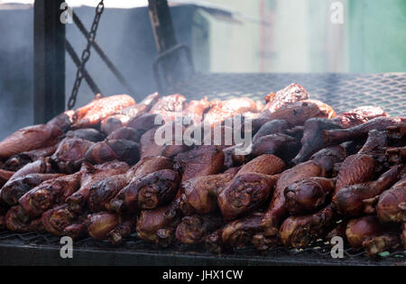 Türkei-Beine auf einem Grill kochen auf einem Messegelände geraucht. Stockfoto