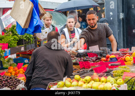 Ein Mann kauft einige Produkte aus Obst und Gemüse Stall in Portobello Market, Notting Hill, London. Stockfoto