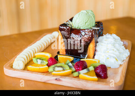 Honig, Toast und Sahne mit Schokoladensauce, Obst und Eis Stockfoto