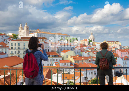 Lissabon, Alfama, eine Frau nimmt ein Foto der Alfama Skyline von der Aussichtsterrasse des Largo das Portas do Sol, hoch oben in der alten Stadt, Lissabon. Stockfoto