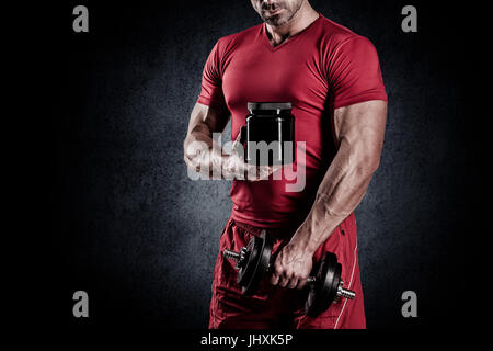 schönen jungen muskulösen Mann mit einer Sporternährung und Hanteln in die Hände von Stockfoto