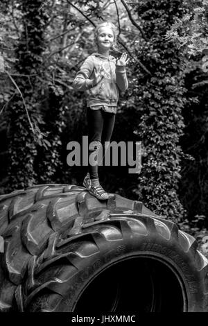 Kinder spielen auf einem Gummireifen auf dem Spielplatz Stockfoto