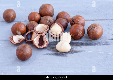 Macadamia ist eine australische Nuss, ein Kindal. Auf einem hölzernen Fob ist eine grau-blaue Farbe. Stockfoto