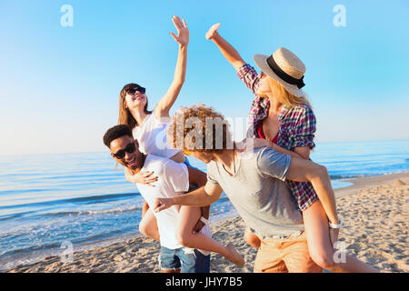 Fröhliche junge Freunde, genießen im Sommer am Strand Stockfoto