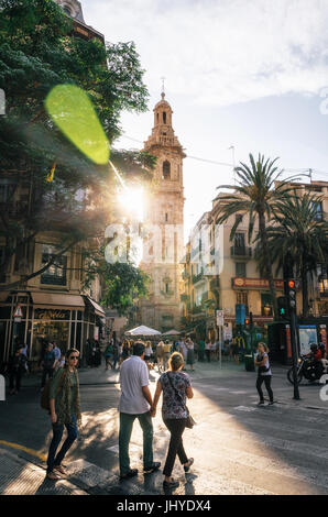 Valencia, Spanien - 3. Juni 2017: Streetview mit Santa Caterina Turm und vorbeifahrenden Touristen bei Sonnenuntergang mit hellem Sonnenlicht, Plaza De La Reina, Valencia Stockfoto