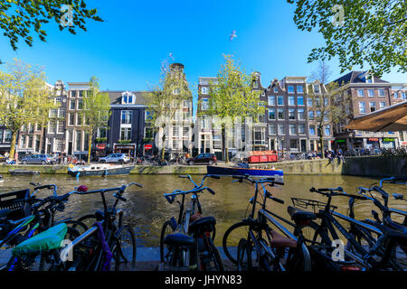 Fahrräder parken an den Ufern des Flusses Amstel und typische Häuser, Amsterdam, Holland (Niederlande), Europa Stockfoto