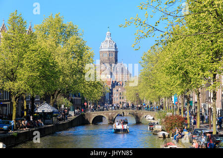 Die alte Kirche (Oude Kerk) eingerahmt von Booten und Brücken in einem Kanal des Flusses Amstel, Amsterdam, Holland (Niederlande) Stockfoto