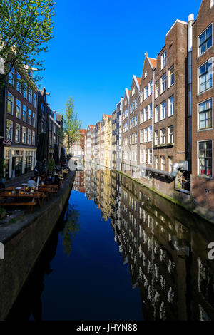 Typische Häuser spiegeln sich in dem blauen Wasser des einen Kanals, Amsterdam, Holland (Niederlande), Europa Stockfoto