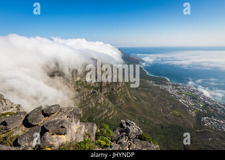 Table Mountain abgedeckt in einer Tischdecke der orographisch Wolken, Camps Bay unten bedeckt in niedrigen Wolken, Cape Town, Südafrika Stockfoto